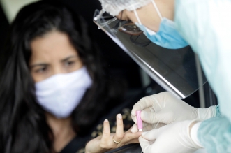 A medical professional conducts tests for the coronavirus disease (COVID-19) in front of Mane Garrincha Stadium, amid the outbreak, in Brasilia, Brazil, April 21, 2020. REUTERS/Ueslei Marcelino